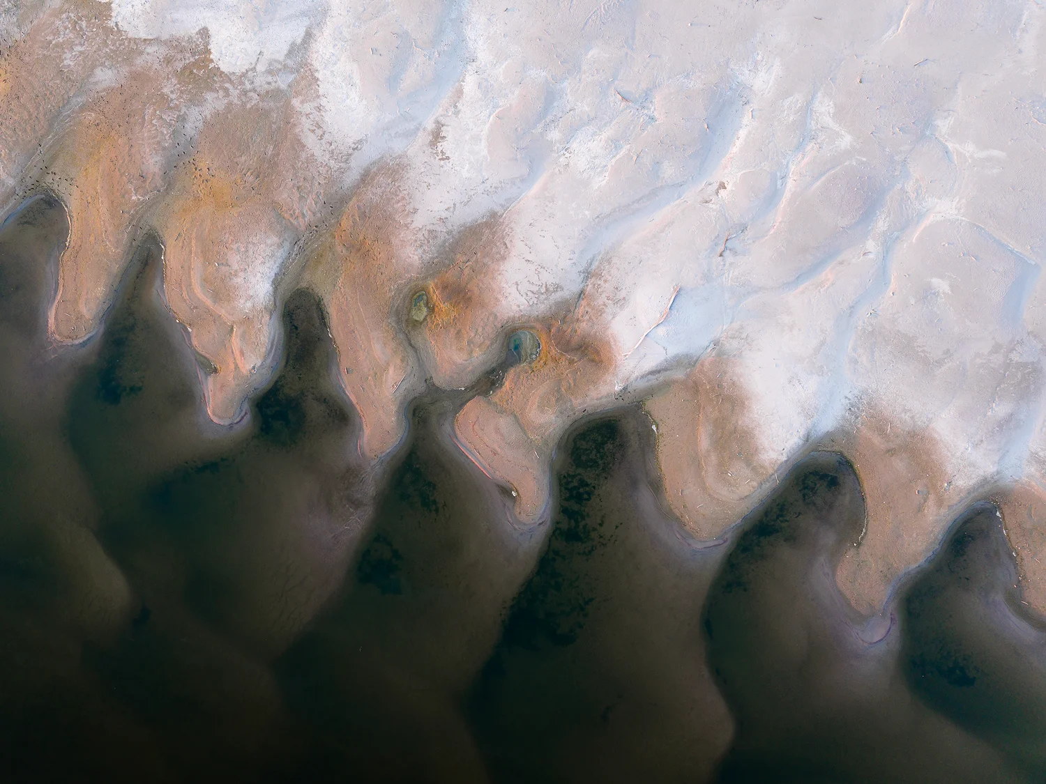 Abstract patterns of sand and water on the Danube River during low summer levels.